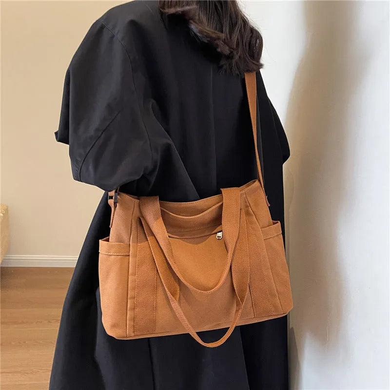 Solid colour polyester tote bag with large capacity and a mobile phone pocket.