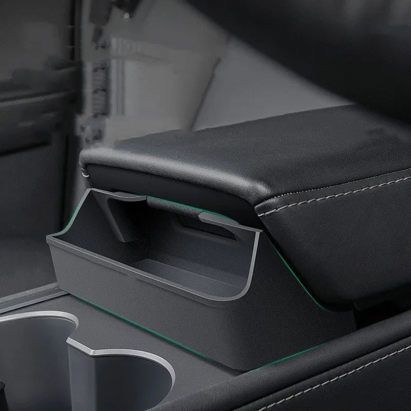 Black silicone glasses storage case accessory installed in a Tesla Model 3 or Y centre console armrest.