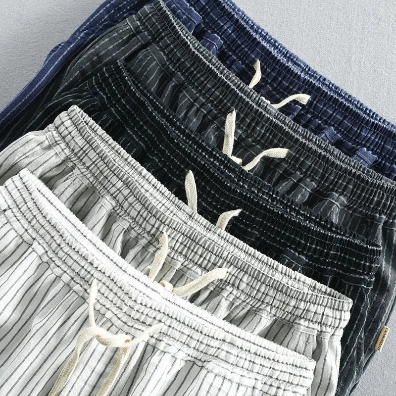Man wearing striped casual cotton shorts with a loose straight fit and elasticated mid waist.