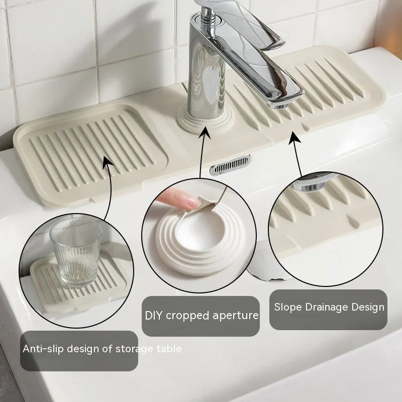 Silicone faucet splash guard pad in beige colour with sloped design and two drain holes on a kitchen sink.