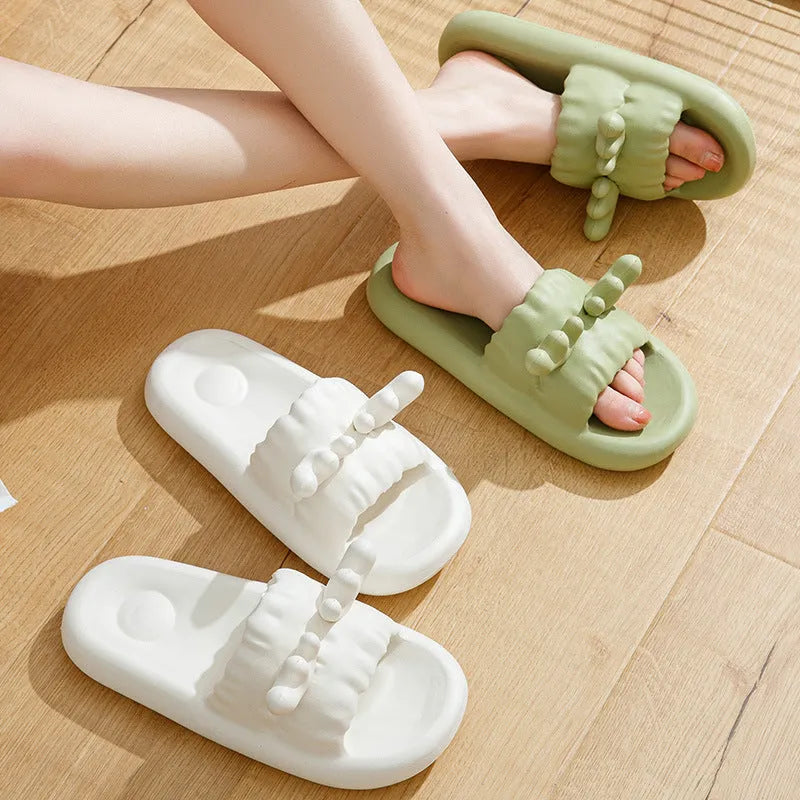 Pair of light-coloured EVA flip flop slippers with hollow-out design and textured sole.