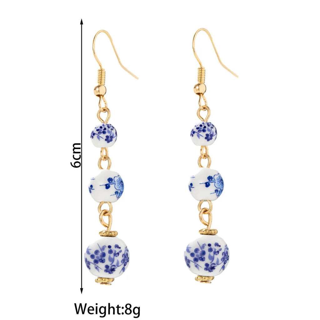 Long blue and white porcelain ceramic bead earrings with geometric Chinese-style design.