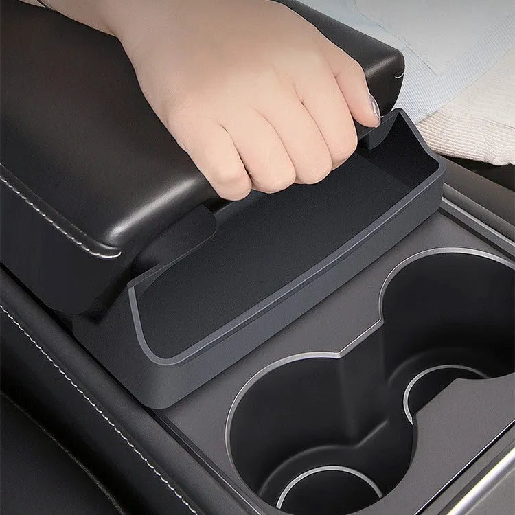 Black silicone glasses storage case accessory installed in a Tesla Model 3 or Y centre console armrest.