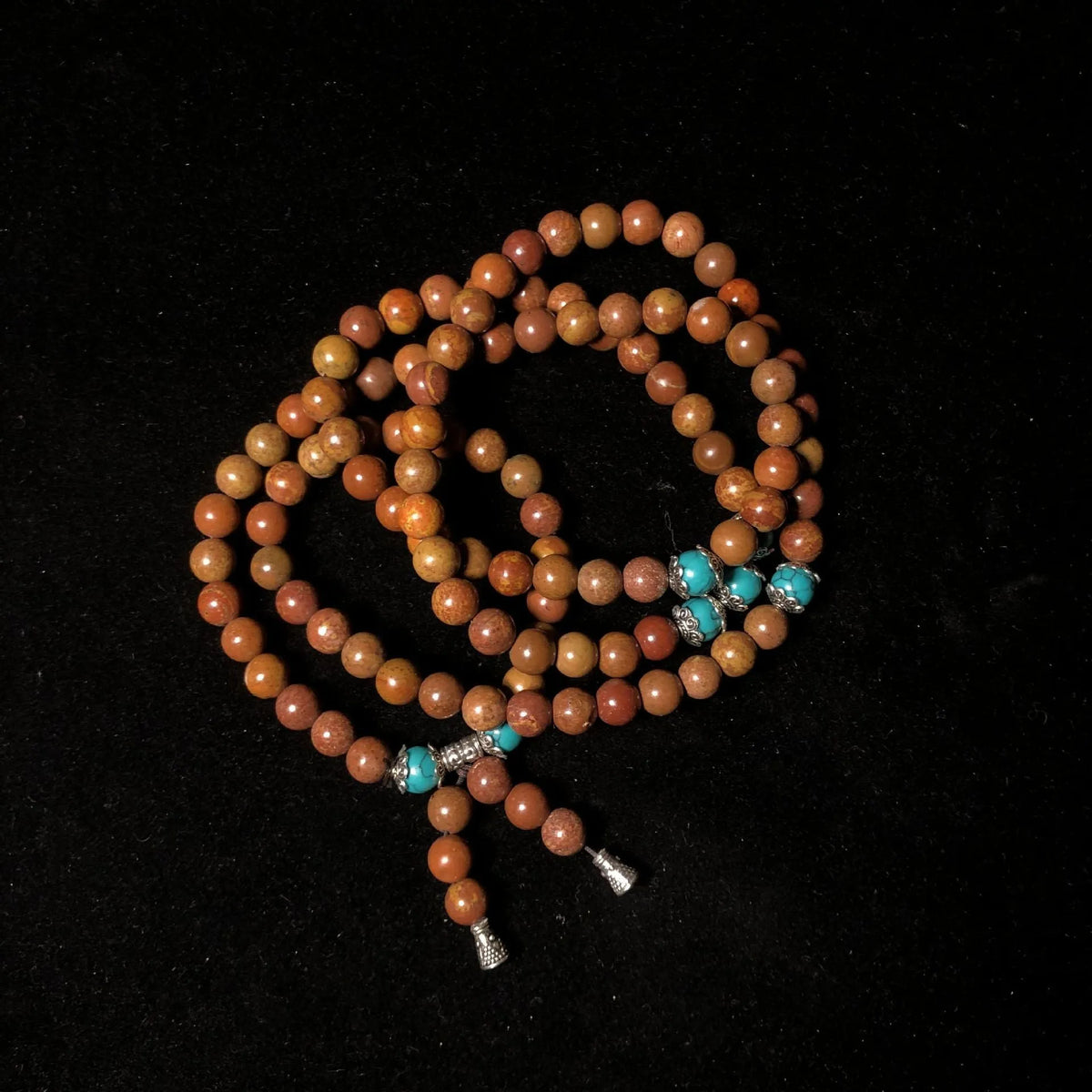 Handmade stone bead bracelet with 108 round geometric beads on a wrist.