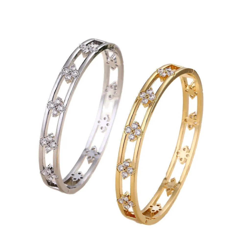 Gold and silver hollow women's bracelets with four-leaf clover zircon charms on a white background.
