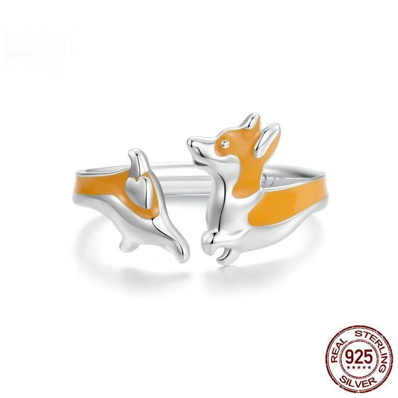 Cartoon-style silver corgi dog ring on a plain background.