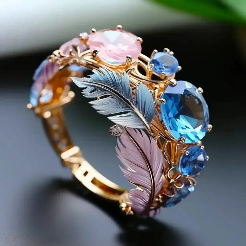 Brass feather ring with embossed colourful design and zircon accents in gold colour