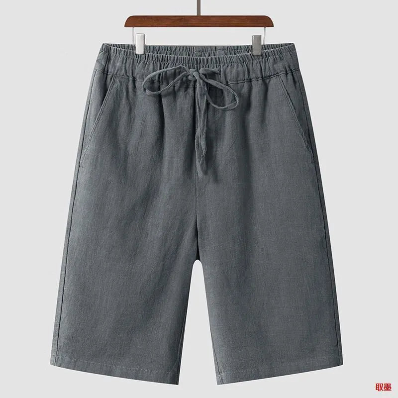 Men's beige linen shorts with a loose cropped fit and mid waistband.