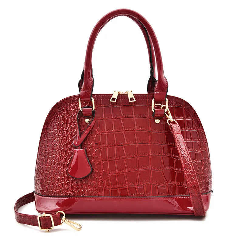 Large shiny PU leather crossbody bag in shell shape design showing black colour option