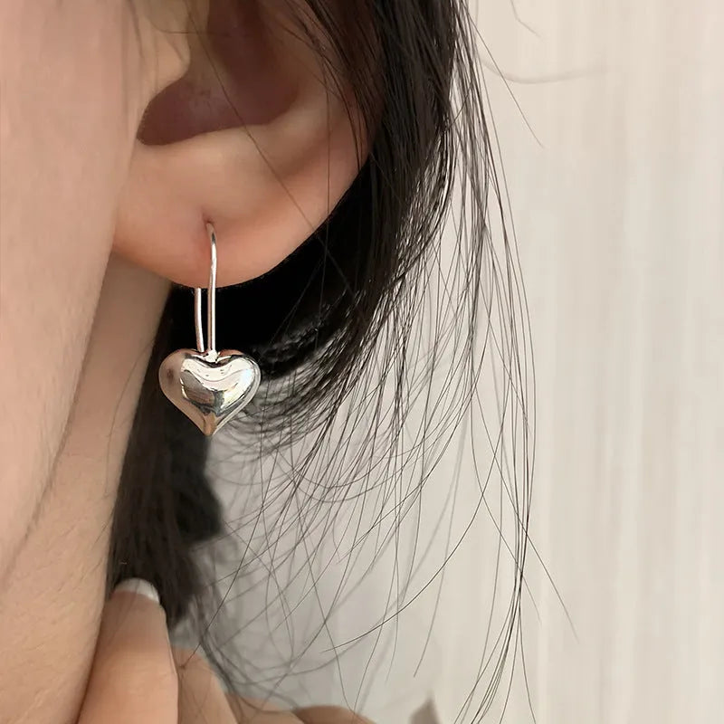 Silver heart-shaped copper earrings with three-dimensional glossy finish and Korean-style design