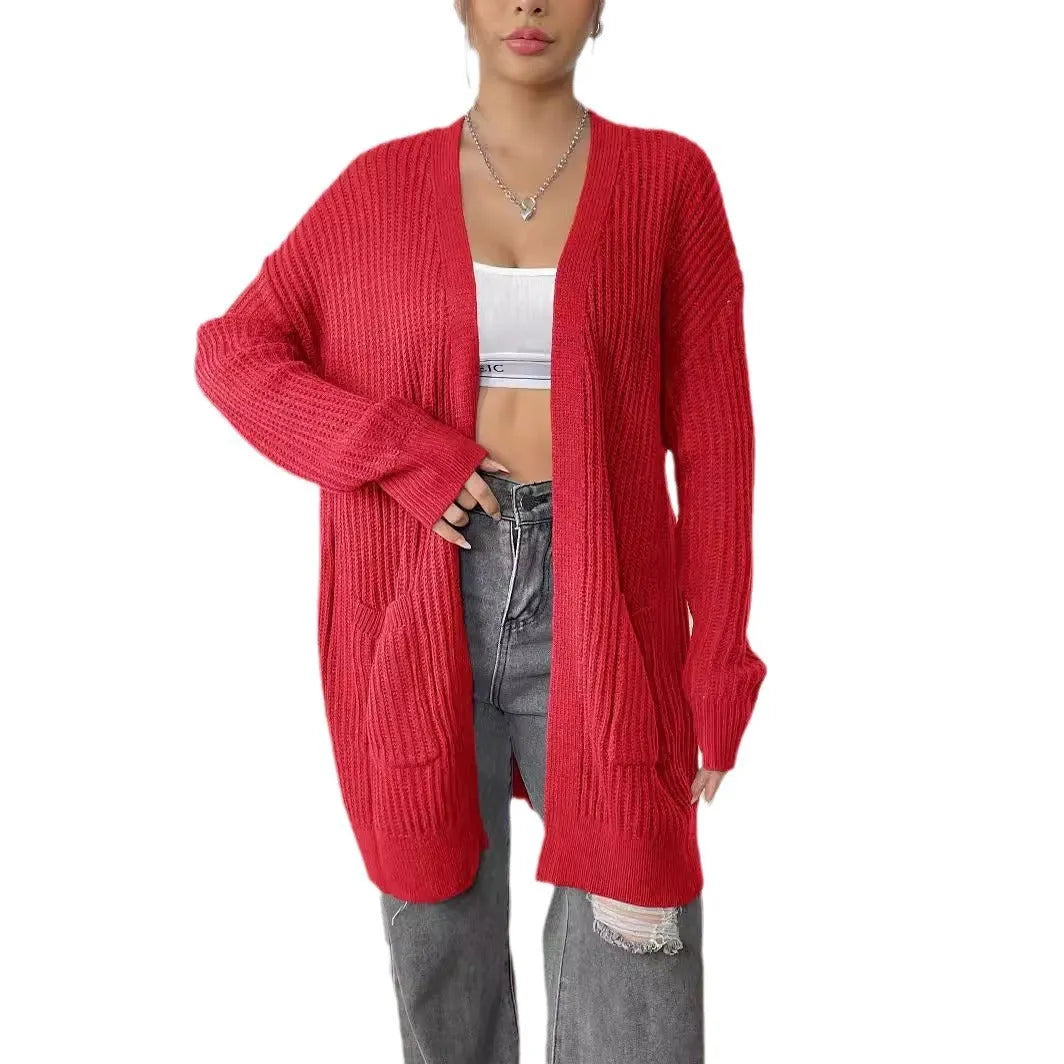 Women's dark green loose fit acrylic cardigan sweater with long sleeves on a hanger.