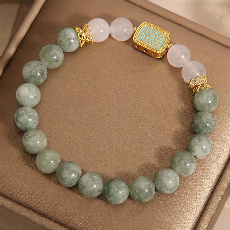 Women's oil green emerald crystal bracelet with five scriptures design on a wrist.