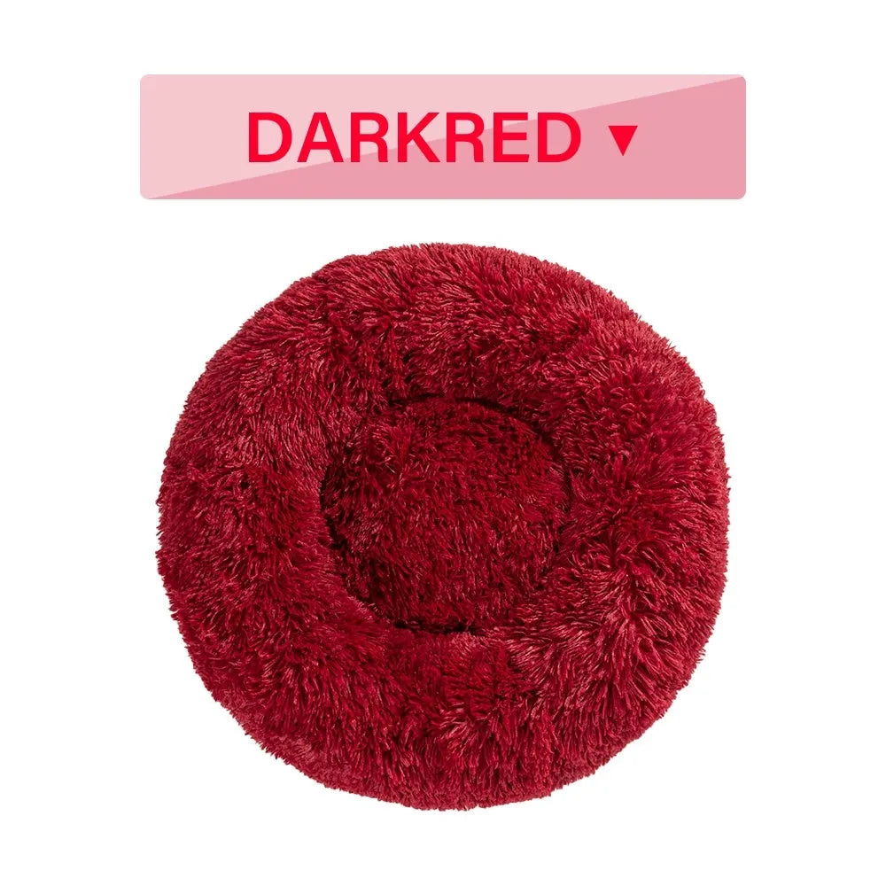 Fluffy donut-shaped dog bed in long plush material, showing raised rim and central cushion.