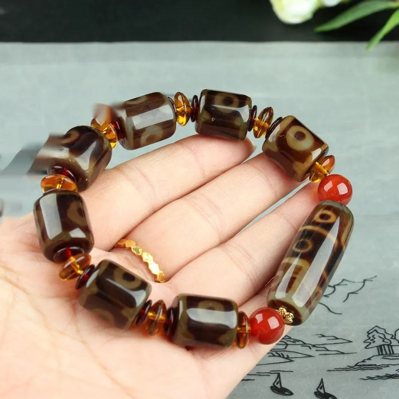 Distressed agate bracelet with traditional Tibetan dzi beads including three-eye and Nine Eyes designs.