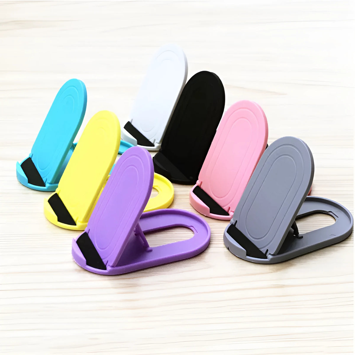 Plastic lazy bracket mobile phone stand in six colour options: black, blue, grey, pink, white, and yellow.