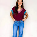 Burgundy loose-fit V-neck sweater with contrast trim on the cuffed short sleeves.