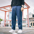 Men's loose straight leg jeans in dark blue cotton denim with a mid-rise waist and zipper fly