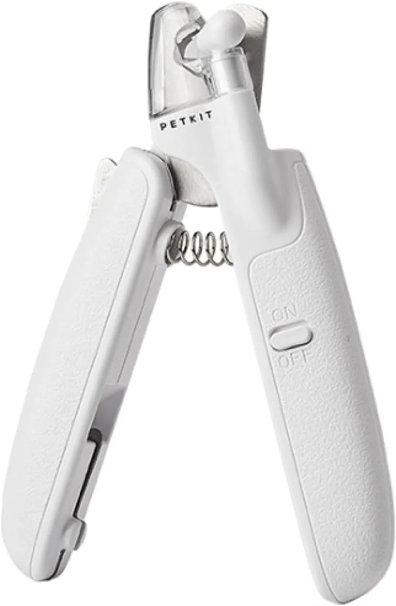 White pet nail clippers with LED light, transparent guard, and leather-like handle next to a nail file.