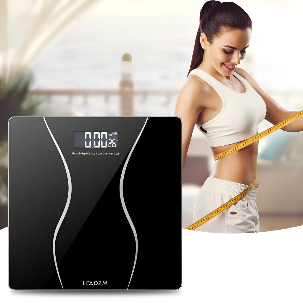 Black electronic bathroom scale on a floor, showing digital display and low-profile platform design.
