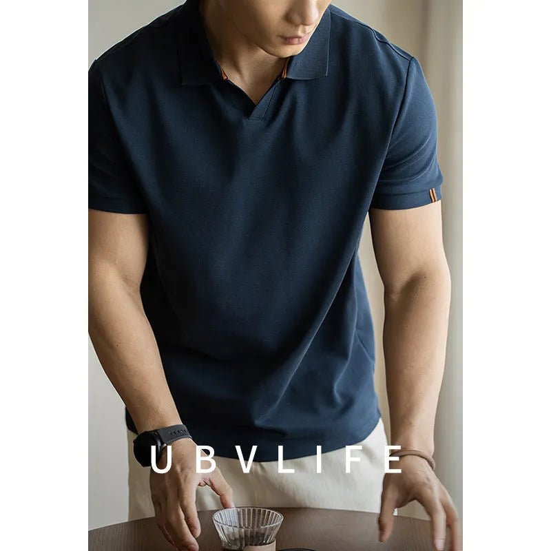 Man wearing a classic blue short-sleeved cotton blend polo shirt, showing regular fit and button placket.