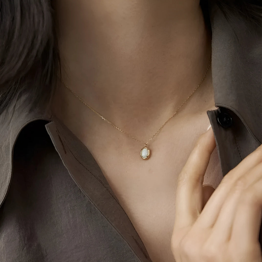 Jelly opal gemstone set in a geometric oval sterling silver pendant necklace.