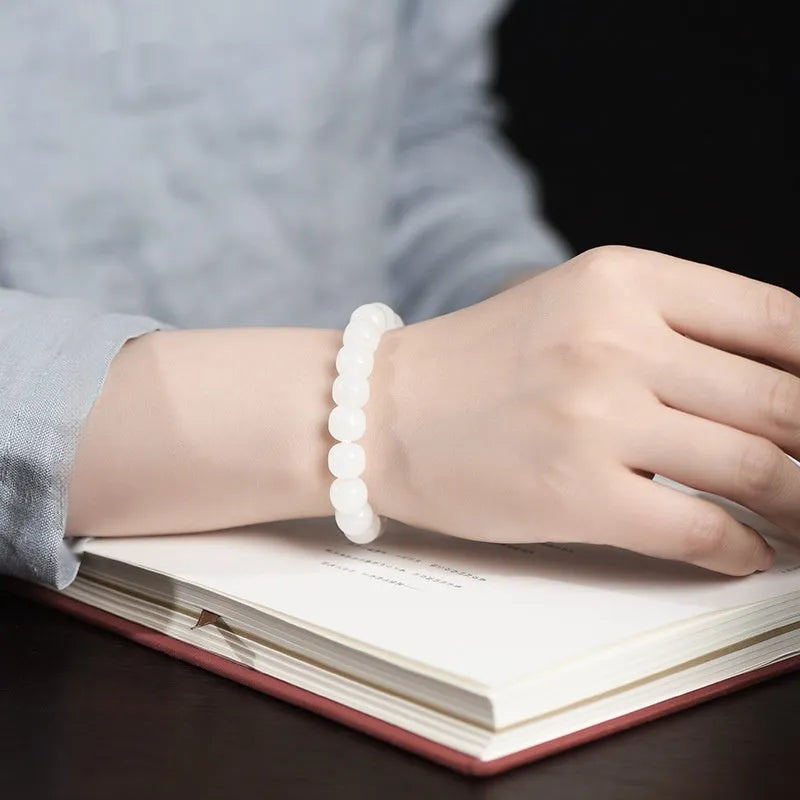 White Hetian jade barrel bead bracelet for men and women on a wrist.