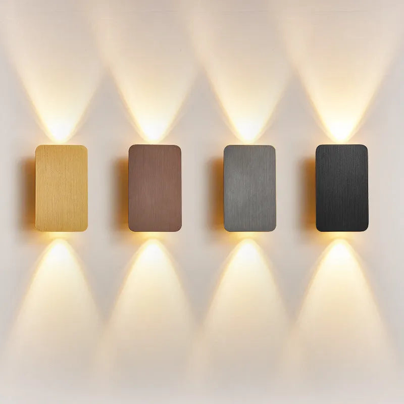 Minimalist modern wall lamp with a slim metal frame in a choice of four finishes, mounted on a wall.