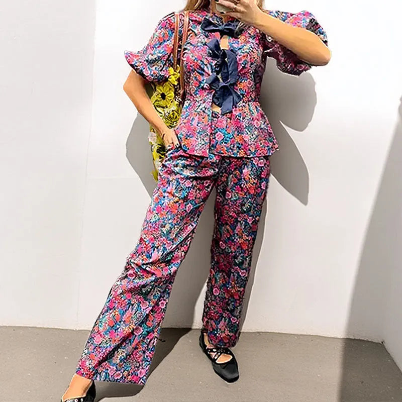 Floral print trousers suit with tie-neck blouse and puff sleeves on hanger