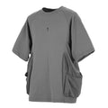 A man wearing a loose grey cotton T-shirt with two large front chest pockets.