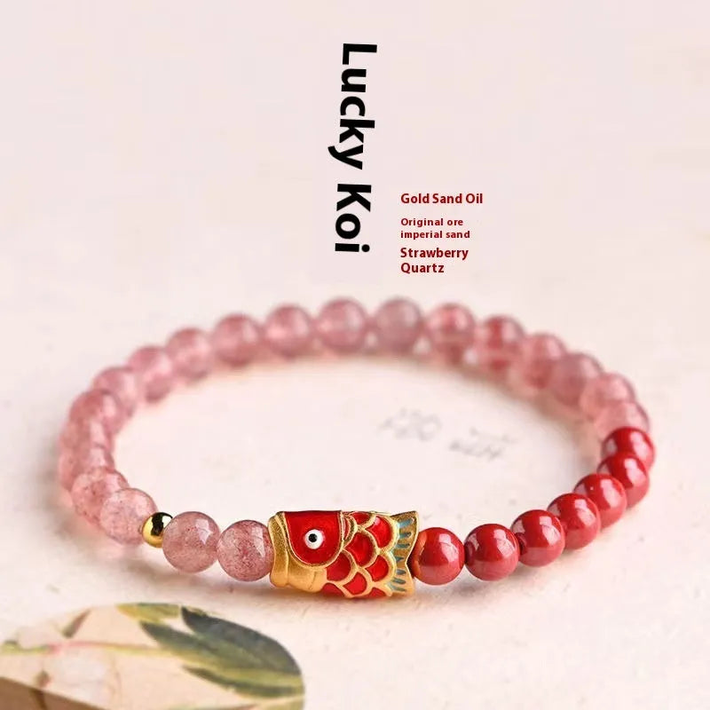 Purple cinnabar and strawberry quartz bracelet with peach blossom and koi charms on a wrist.