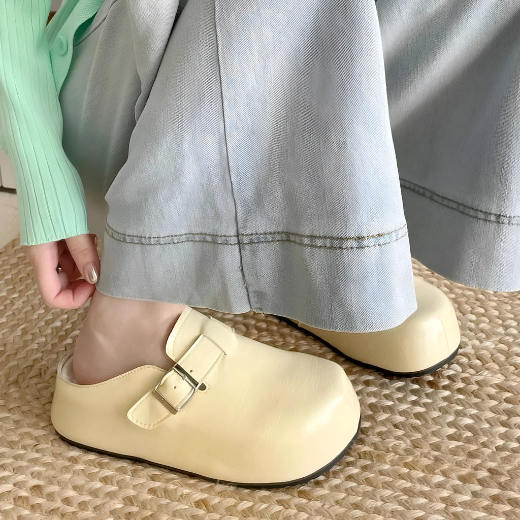 Casual flat buckle sneakers in yellow with round toe, shown on a white background.