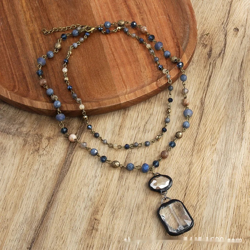 Two-layer tribal-style chain necklace with glass pendant and stone elements in beige and blue colour options