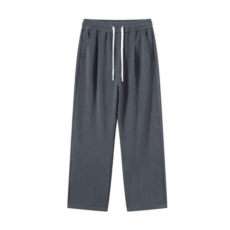 Man wearing loose apricot fleece-lined sports trousers with a drawstring waistband.