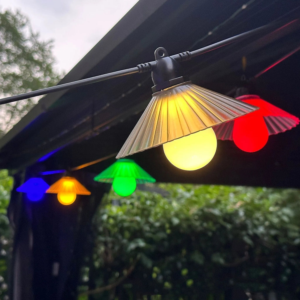 Outdoor flower-shaped LED string lights with IP65 rating hung in a garden setting.