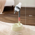 Green adjustable pet water dispenser with detachable pole and steel drinking nozzle on a grey floor.