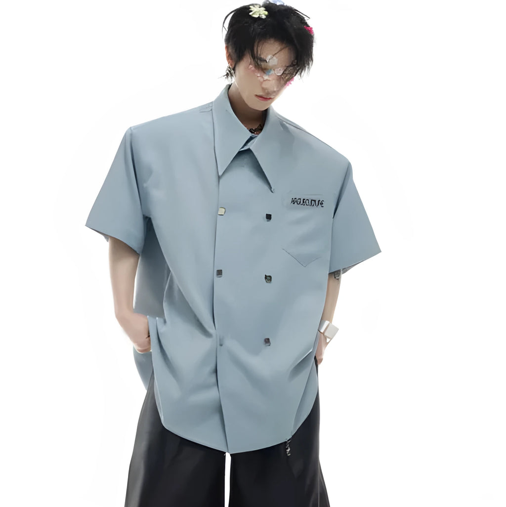 Man wearing a loose fit blue short sleeve casual shirt with a lapel collar and splicing detail.
