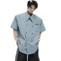 Man wearing a loose fit blue short sleeve casual shirt with a lapel collar and splicing detail.