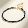 Blue tourmaline bracelet with 3mm beads and spacer beads on a wrist.