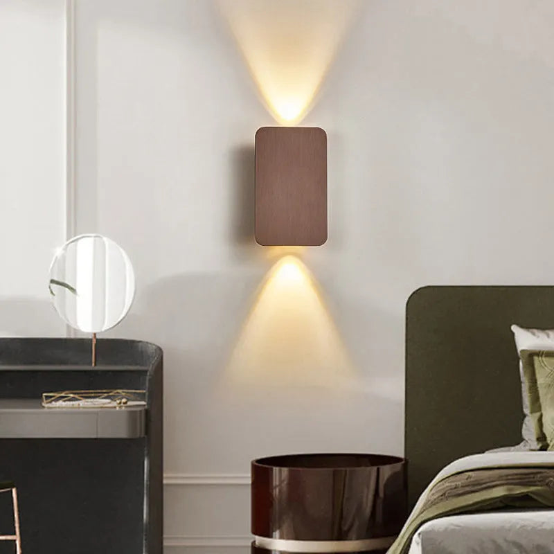 Minimalist modern wall lamp with a slim metal frame in a choice of four finishes, mounted on a wall.