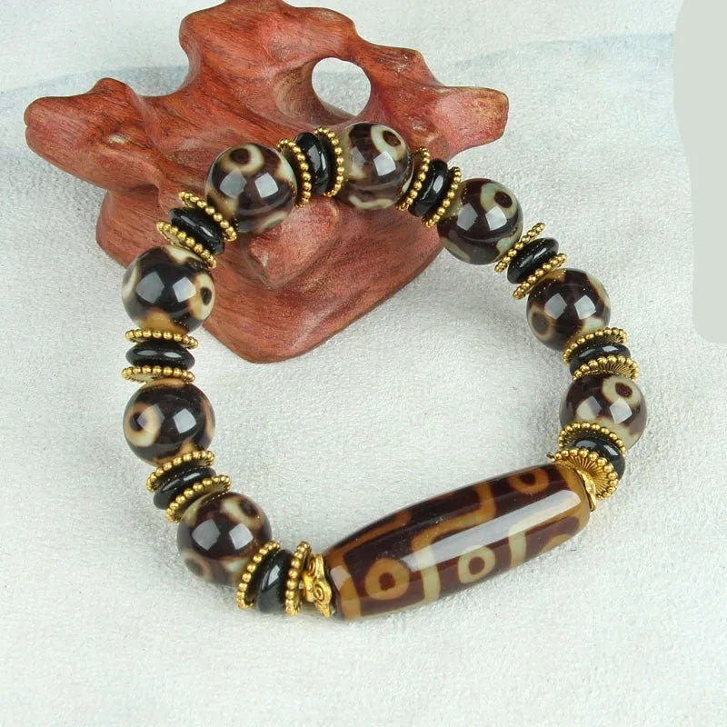 Distressed agate bracelet with traditional Tibetan dzi beads including three-eye and Nine Eyes designs.