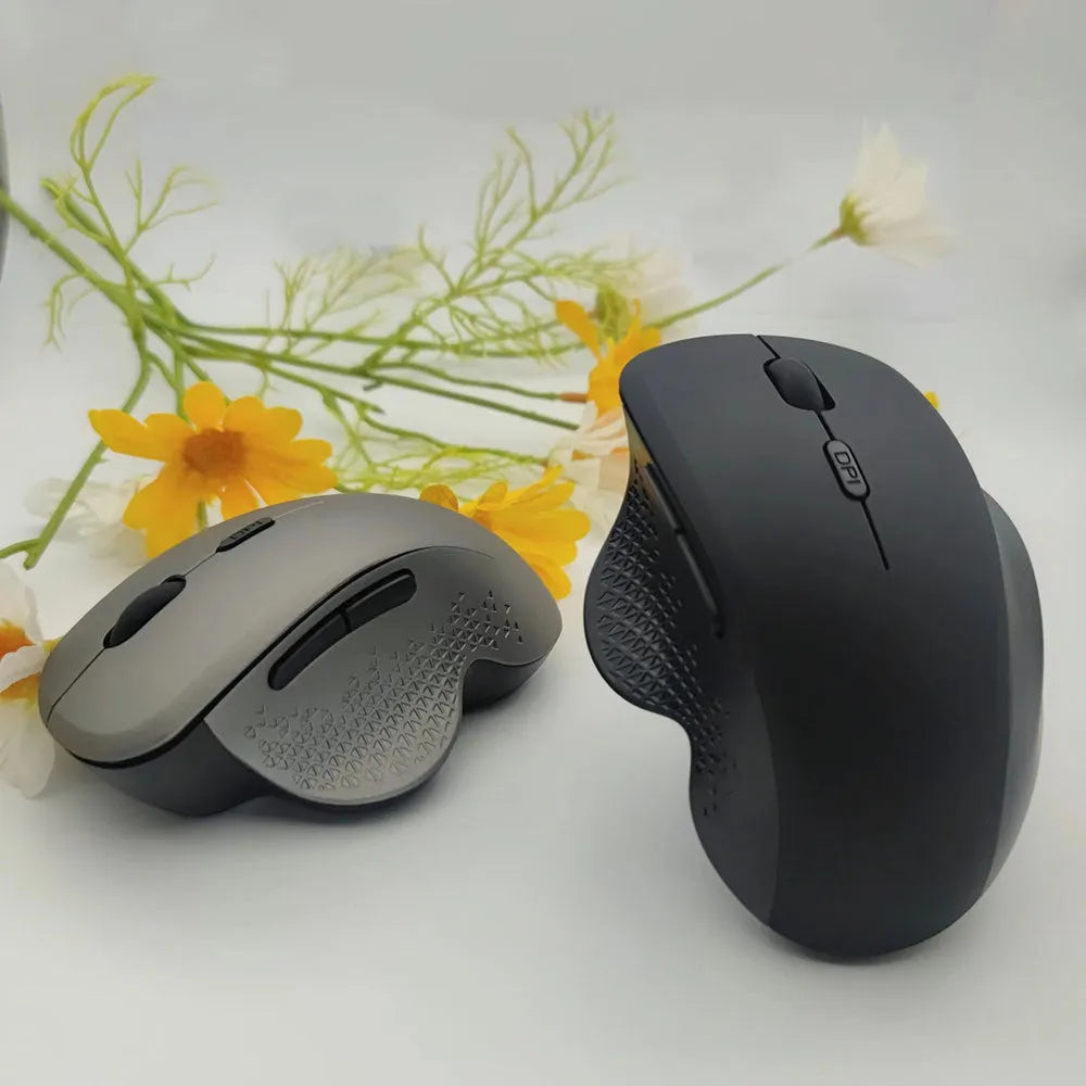 Grey and black wireless computer mouse with USB charging cable on a white box