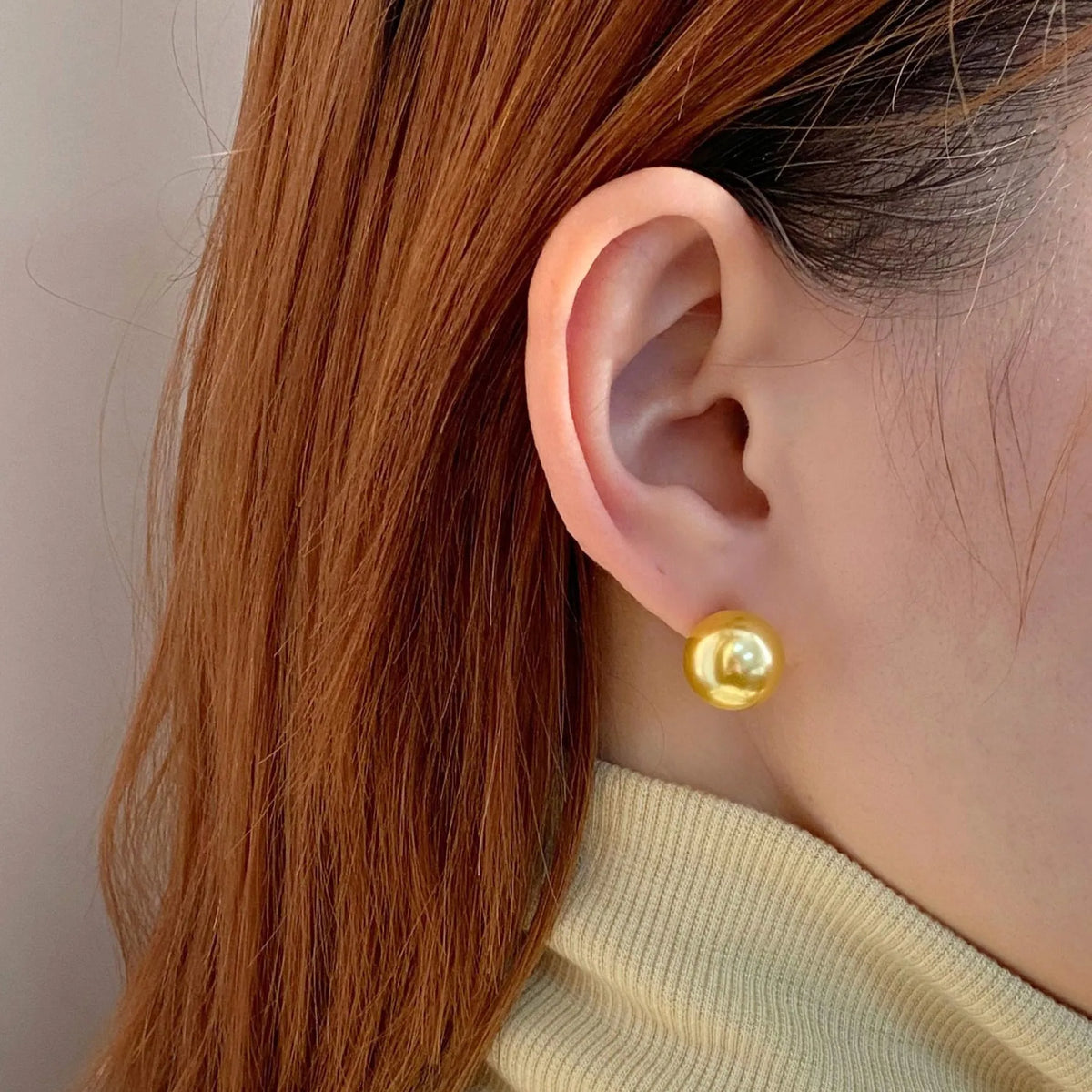 A pair of large geometric pearl stud earrings with an eight-point star detail on a silver setting.