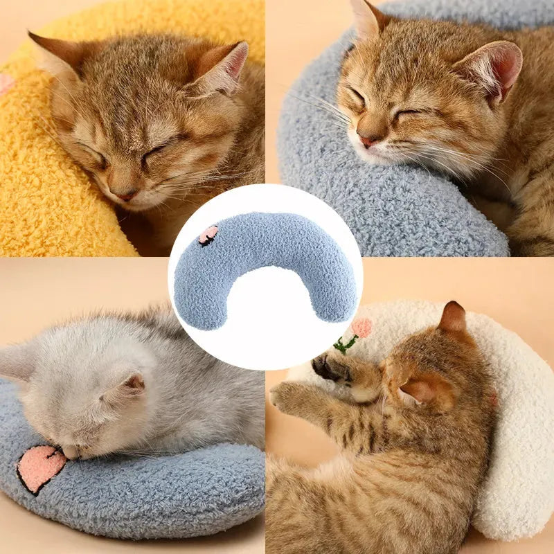 Small blue half-donut shaped pet pillow bed for cats or small dogs on a carpet.
