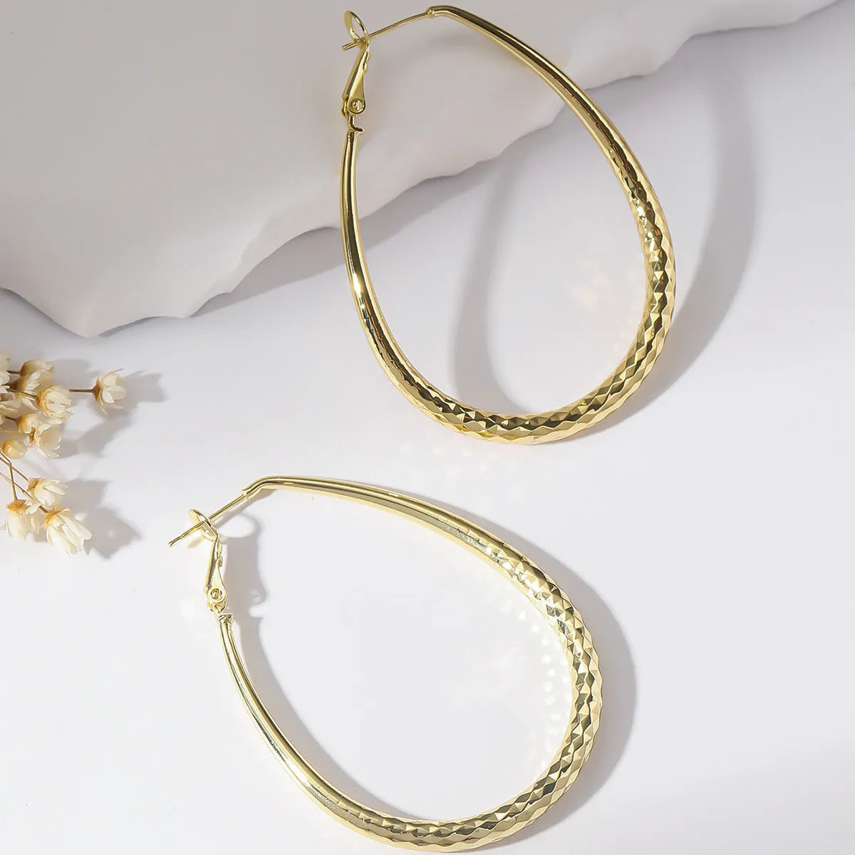 Gold egg-shaped copper earrings with hypoallergenic posts and spring fasteners, unisex geometric ellipse design