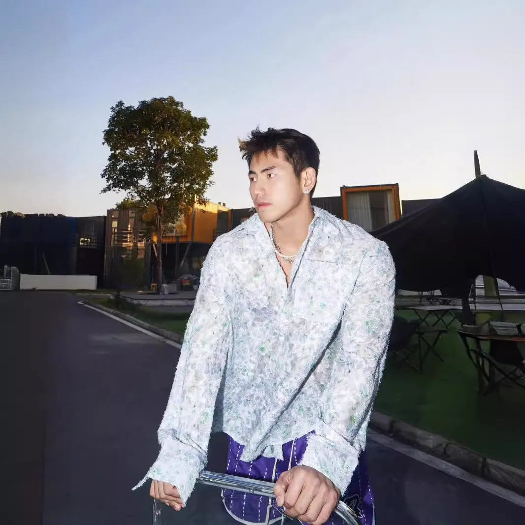 Man wearing a blue floral embossed long sleeve shirt with a loose fit