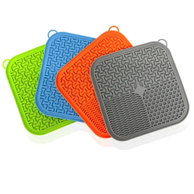 Blue silicone dog lick mat with textured pattern and suction cups on a table.