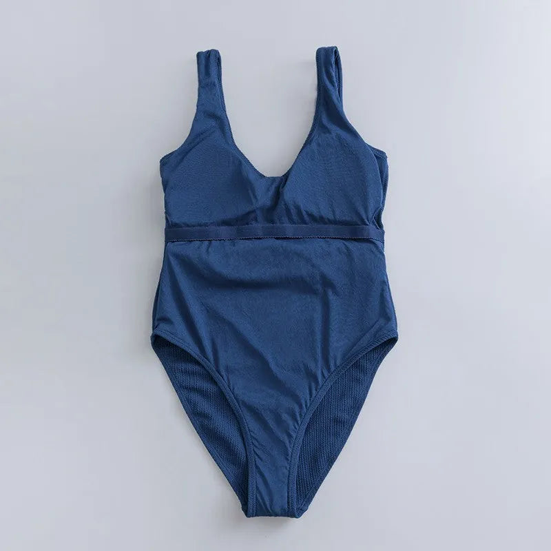 Navy blue women's one-piece swimsuit with triangle design and chest padding on a mannequin.