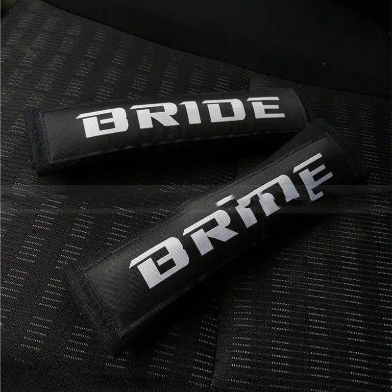 Pair of black car seat belt shoulder pad sleeves with embroidery detail, showing dimensions.