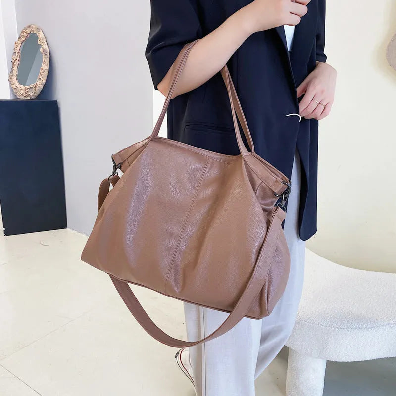 Large soft surface messenger bag in horizontal square shape with adjustable shoulder strap and zipper opening