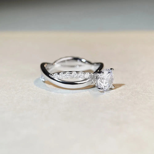 Geometric cross design moissanite ring with twisted sterling silver band and four-claw setting.
